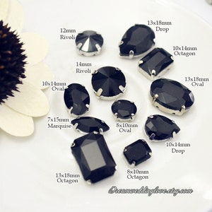 Könnte beinhalten: Eine Auswahl schwarzer Kristall-Strasssteine in verschiedenen Formen, darunter oval, Tropfen, Achteck und Marquise. Größen von 7x15mm bis 13x18mm. Jeder Stein hat eine silberfarbene Metalleinfassung. Der Etsy-Shop-Name ist sichtbar.