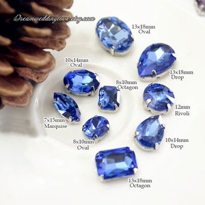 Puede incluir: Surtido de piedras de cristal azul en diferentes formas y tamaños, incluyendo formas ovaladas, octogonales, marquesa y gota. Las piedras están engastadas en monturas plateadas. Los tamaños se indican en milímetros.