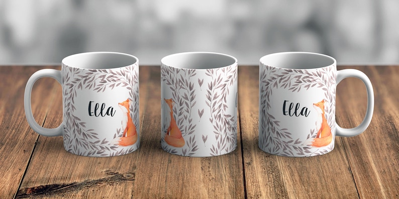 May include: Three white ceramic mugs with a grey and white leafy design and a fox illustration. The mugs have the name "Ella" printed on them.