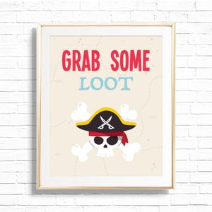 May include: A framed pirate-themed print with the words "GRAB SOME LOOT" in red and blue. The image features a skull with a pirate hat, crossed swords, and a red bandana, set against a map-like background.
