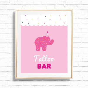 May include: A framed pink print featuring a pink elephant wearing a party hat and covered in colorful confetti. The words "Tattoo BAR" are written in white and pink below the elephant. The background is a solid pink color.