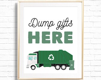 May include: A white framed print with the text "Dump gifts HERE" in green and black. A green garbage truck with a recycling symbol is pictured below the text.