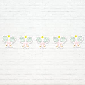 May include: A banner featuring five tennis racket and ball cutouts. Each cutout has a light green racket, a yellow tennis ball, and a pink bow. The banner is set against a white brick wall.