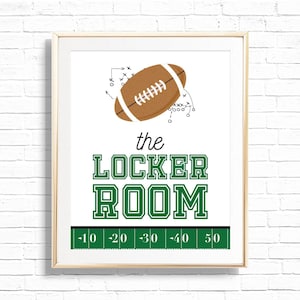 May include: Framed print with a football illustration and the words "the LOCKER ROOM" in green. A brown football with white laces is at the top, with play diagrams. A green field graphic with yard lines is at the bottom.