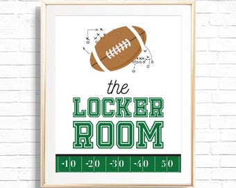 May include: Framed print with a football illustration and the words "the LOCKER ROOM" in green. A brown football with white laces is at the top, with play diagrams. A green field graphic with yard lines is at the bottom.