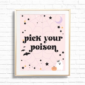 May include: A framed Halloween-themed print with a light pink background featuring a spiderweb design, stars, bats, candy corn, a crescent moon, a pumpkin, and a ghost. The text "pick your poison" is in black script.