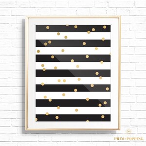May include: A framed print with a black and white striped background and gold confetti scattered throughout.
