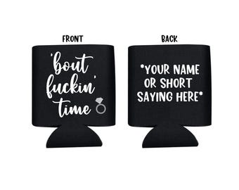 Pode incluir: Resfriador de latas preto e branco com o texto 'bout fuckin' time' e um gráfico de anel de diamante na frente. A parte de trás tem o texto '*YOUR NAME OR SHORT SAYING HERE*' em branco.