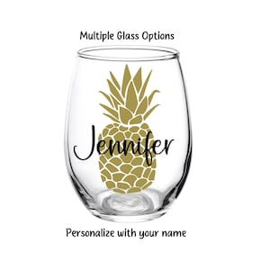 May include: Personalized stemless wine glass with a gold pineapple design and the name "Jennifer".