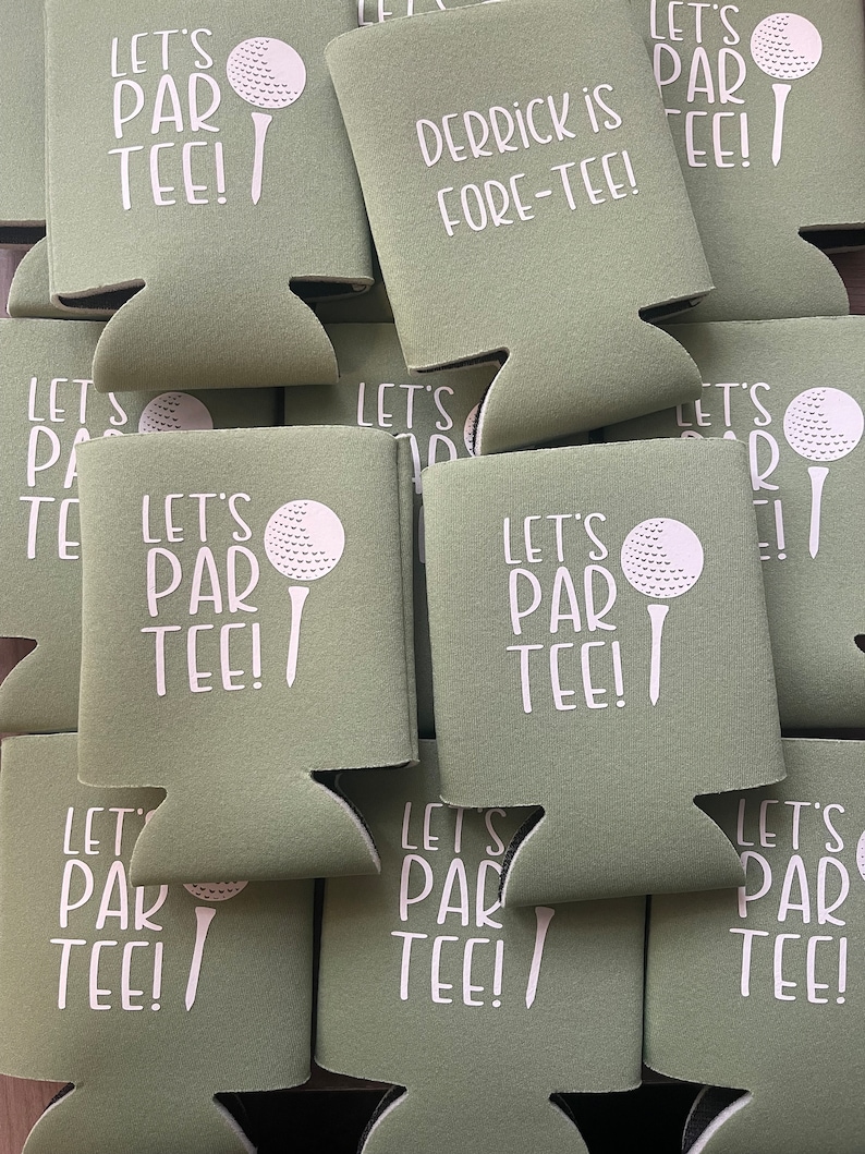 May include: A stack of green foam can coolers with white text and a golf ball graphic. The text on the coolers reads "Let's Par Tee!" and "Derrick is Fore-Tee!"