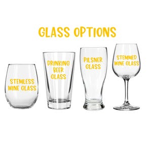 May include: Four different glass options for drinking: a stemless wine glass, a drinking beer glass, a pilsner glass, and a stemmed wine glass. All glasses are clear and have text printed on them in yellow.
