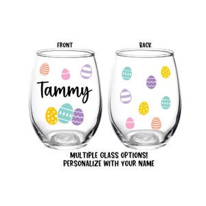 May include: Two clear glass wine glasses with a personalized Easter design. The front glass has the name "Tammy" and the back glass has a pattern of colorful Easter eggs.