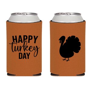 May include: Two brown foam can coolers with black text and images. One cooler says "Happy Turkey Day" and the other has a silhouette of a turkey.