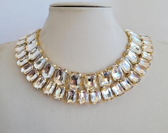 May include: A gold chain necklace with two rows of large, clear, rectangular-shaped crystals.