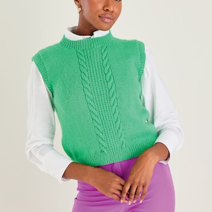 Puede incluir: Un chaleco de punto verde con cable y cuello redondo. El chaleco es corto y tiene un ajuste holgado.