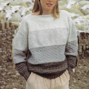 May include: A white, gray, and brown striped knitted sweater with a boat neck.