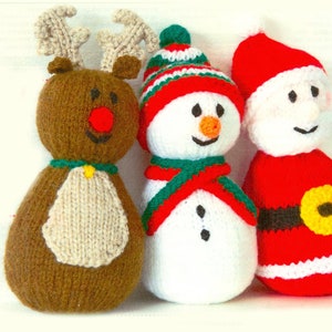 May include: Three knitted Christmas decorations: a brown reindeer with a red nose, a white snowman with a green scarf and red hat, and a red Santa Claus with a yellow belt.