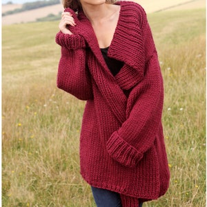 May include: A long, burgundy cardigan with a wide, folded collar. The cardigan is knit with a chunky yarn and has a relaxed fit.