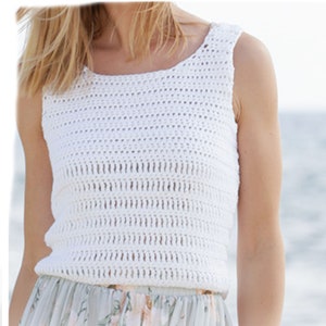 May include: White crochet tank top with a loose, open weave. The tank top has a scoop neck and sleeveless design.