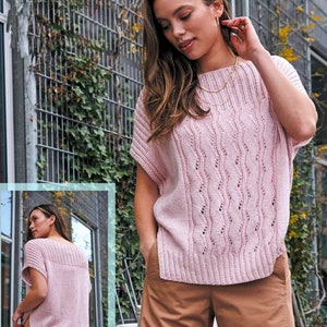 Può includere: Un maglione di maglia rosa con un delicato motivo traforato e maniche corte. Il maglione ha una vestibilità rilassata e un orlo posteriore leggermente più lungo.