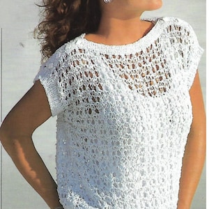 May include: White crochet top with a loose fit and short sleeves. The top features a delicate openwork pattern and a slightly gathered hem.