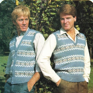 May include: Two men wearing blue and white patterned knit vests. The vests have a V-neck and button closure. The men are wearing white shirts and brown pants.