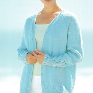 May include: A light blue cardigan with a button-up front and a delicate lace pattern on the sleeves and hem.