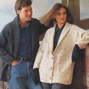 May include: Two people wearing knitted cardigans. The person on the left is wearing a dark gray cardigan with a wide collar. The person on the right is wearing a cream cardigan with a speckled pattern and a wide collar.