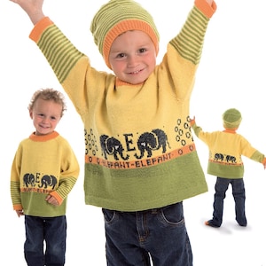 Puede incluir: Un suéter de punto amarillo y verde con diseños de elefantes negros y el texto "O ELEFANT-ELEFANT O". El suéter tiene rayas naranjas en las mangas y el cuello. También se muestra un gorro a juego de rayas verdes y naranjas.