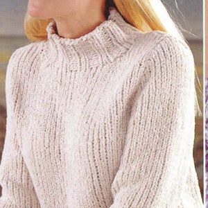 May include: A white knitted jumper with a high neck and long sleeves. The jumper has a ribbed texture and a slightly loose fit.