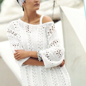 Può includere: Un maglione bianco lavorato a uncinetto con una vestibilità ampia e un delicato motivo traforato. Il maglione ha un collo rotondo e maniche a tre quarti.