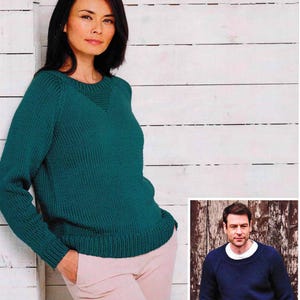 Könnte beinhalten: Zwei Strickpullover, einer türkis und einer marineblau, mit Rundhalsausschnitt und langen Ärmeln. Die Pullover werden auf Modellen vor einem weißen Holz Hintergrund und einem Holzpaneel Hintergrund gezeigt.