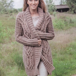 May include: A long, brown cable knit cardigan with a wide collar. The cardigan is open in the front and has a loose fit.
