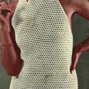 May include: A white crochet halter top with a geometric pattern. The top has a high neckline and a criss-cross design at the front.