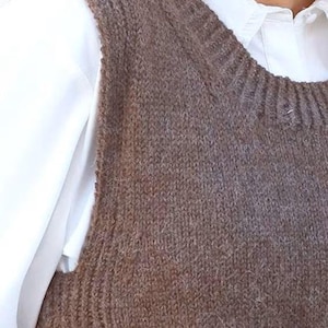 以下が含まれることがあります： 丸首のブラウンのニットのノースリーブセーターベスト