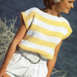 May include: A woman wearing a white and yellow striped crocheted top with a white crocheted headband. She is wearing white shorts with a white braided belt and a silver buckle.