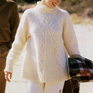 May include: A white knitted jumper with a cable knit pattern. The jumper has a high neck and long sleeves.