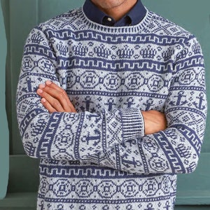 Puede incluir: Un suéter azul y blanco con un diseño de ancla. El suéter tiene cuello redondo y mangas largas.