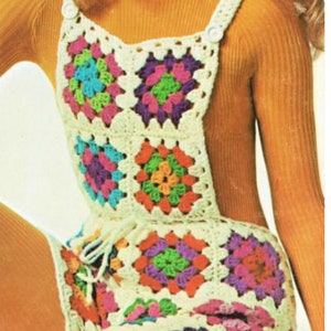May include: A white crochet jumpsuit with colorful squares. The jumpsuit has a high neckline and a button closure at the shoulder. The model is wearing a turtleneck sweater underneath.