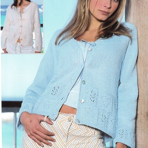 May include: A light blue knitted cardigan with a v-neck and button fastening. The cardigan features a delicate lace pattern on the front and sleeves. The model is wearing the cardigan over a white vest top and striped shorts.