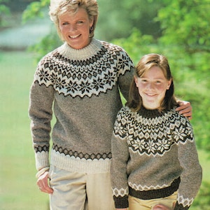 Könnte beinhalten: Zwei Personen tragen braune und weiße gemusterte Pullover mit Rundhalsausschnitt. Die Pullover haben ein geometrisches Muster in Braun, Weiß und Grau.
