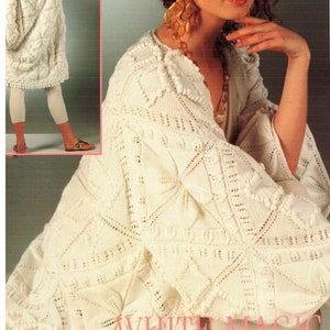 Pode incluir: Casaco branco de malha com uma borda de renda. O casaco apresenta grandes motivos com folhas em relevo. "WHITE MAGIC" está escrito no canto inferior direito da imagem.