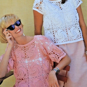 Puede incluir: Dos tops de crochet, uno blanco y otro rosa, con un patrón cuadrado. Los tops tienen mangas cortas y un escote redondo.
