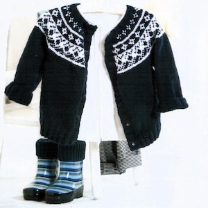 May include: A navy blue knitted cardigan with a white and black geometric pattern on the front and sleeves. The cardigan has a button closure and is hanging on a hanger. Two pairs of blue and white striped rain boots are in the foreground.