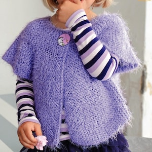 Op de afbeelding: Een paarse, pluche gebreide cardigan met knoopsluiting. De cardigan heeft korte mouwen en een licht uitlopende zoom. Het model draagt er een gestreept longsleeve shirt onder.