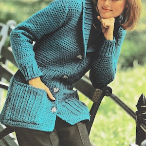 May include: A teal blue crocheted cardigan with a shawl collar, double breasted closure, and two patch pockets.