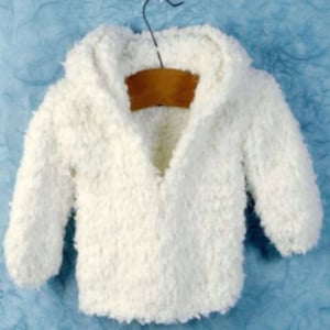 Puede incluir: Un suéter blanco con capucha hecho de material suave y esponjoso. El suéter tiene cuello en V y mangas largas.