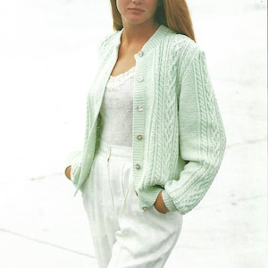 May include: A light green cable knit cardigan with a button closure. The cardigan has a relaxed fit and long sleeves.