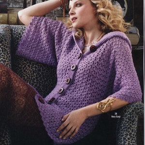 May include: A purple crocheted hooded cardigan with button fastenings. The cardigan has a loose fit and is shown being worn by a model.