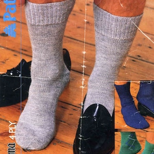 May include: A pair of grey socks with a black loafer shoe. The socks are made of a soft, comfortable material and are perfect for everyday wear. The socks are available in three sizes. The image also shows a pair of blue socks and a pair of green socks.